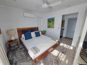 um quarto com uma cama grande e almofadas azuis em Pablos Retreat em Brisbane