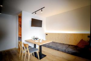 a dining room with a table and a bed at WOLF Apartments Padaun in Vals