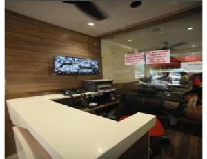 a fast food restaurant with a counter and a tv at HOTEL SHRI RAM RESIDENCY, Agra in Agra