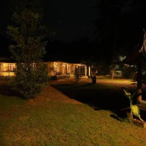 uma casa iluminada à noite com um quintal em Thottupuram Farm House em Thodupuzha