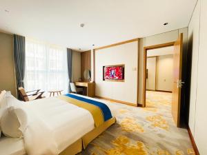 une chambre d'hôtel avec un grand lit et une porte dans l'établissement Phú Long Tam Kỳ Hotel & Restaurant, à Tam Kỳ