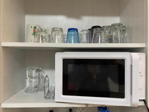 a microwave on a shelf with glasses on it at Appartamento I Castagneti in Pasturo