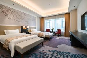 a hotel room with two beds and a television at Guangzhou Pan Yu President Hotel in Guangzhou