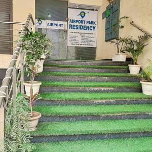 a set of stairs with green grass and plants at Hotel Park Residency By BYOB Hotels in New Delhi