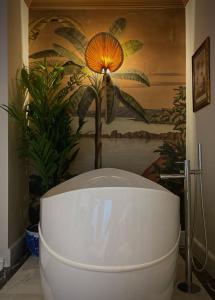 a large white bath tub in a room with a plant at Mono Life Hotel in Bayrakli