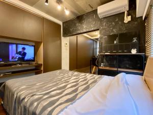 a bedroom with a bed and a flat screen tv at Tokyo Shibuya+2rooms+45m2+4pplmax+Best location+well designed in Tokyo