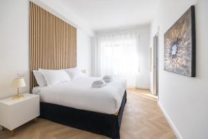 um quarto com uma cama grande e lençóis brancos em Vatican City Apartment em Roma