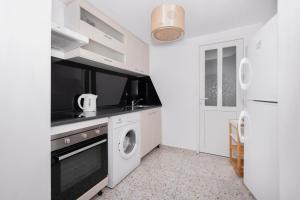 eine weiße Küche mit einer Waschmaschine und einer Waschmaschine in der Unterkunft Your Home in Old Town Brasov in Braşov