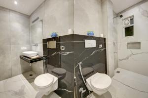 a bathroom with two toilets and a shower at Hotel Transit International- Aerocity Delhi Airport in New Delhi