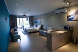 a living room with a bed and a couch at Thalassa Seychelles in Beau Vallon