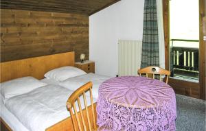 a bedroom with a bed with a table and a window at Ferienwohnung Im Bauernhof in Fusch an der Glocknerstraße +5 photos