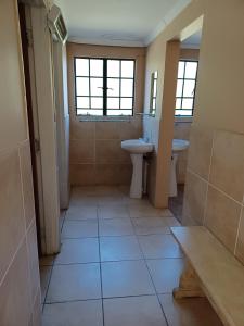 a bathroom with a sink and a toilet and a mirror at Drakensberg Mountain Retreat Barn House in Bergville +17 photos