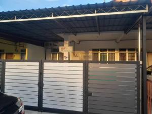 a pair of gates in front of a house at homestay pakjie in Arau