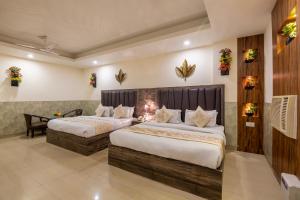 a hotel room with two beds and a desk at Hotel Mahajan International, Delhi Airport in New Delhi