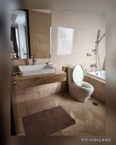 a bathroom with a toilet and a sink and a tub at Menteng Park - Tower Diamond, 2 Bed Rooms, Private Lift in Jakarta