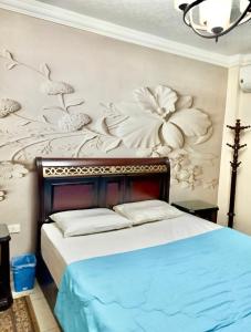 ein Schlafzimmer mit einem Bett mit einem Blumenbild an der Wand in der Unterkunft Gardenia city apartments - 35342 in Kairo