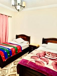 2 Betten nebeneinander in einem Zimmer in der Unterkunft Gardenia city apartments - 35342 in Kairo