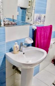 ein Bad mit einem Waschbecken und einem rosa Handtuch in der Unterkunft Gardenia city apartments - 35342 in Kairo