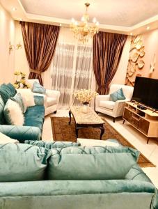 uma sala de estar com sofás azuis e um lustre em Gardenia city apartments - 35342 em Cairo
