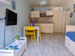 una pequeña cocina con mesa y sillas amarillas en una habitación en Ca' Azzurra, en Albenga