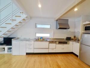 a kitchen with white cabinets and a sink at Hirafu House 7 in Ōmagari