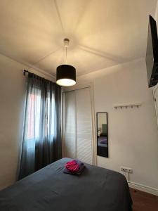 a bedroom with a bed with a lamp and a window at Habitaciones Magdalena in Madrid