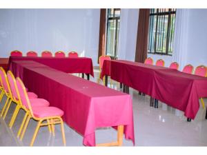una fila di tavoli e sedie con tovaglia rosa di Planete Hotel a Rubavu