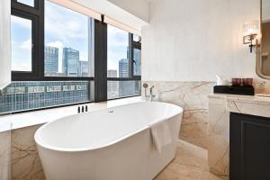y baño con bañera y ventana grande. en Guangzhou Pan Yu President Hotel, en Guangzhou