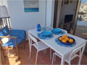 una mesa blanca con platos y tazones de naranjas. en Chic Home Tropical beach Motril with garage en Motril