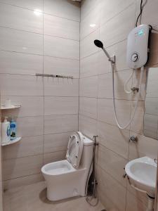 a bathroom with a shower and a toilet and a sink at Mersing Maple Villa in Mersing