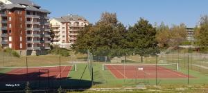 una pista de tenis frente a algunos edificios en studio-cabine 4 pers, wifi et garage. en Ax-les-Thermes