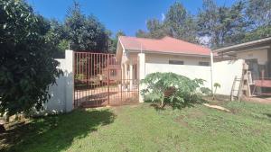 una cerca blanca frente a una casa en Tellis Villa en Arusha