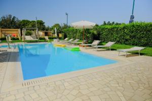 - une piscine avec des chaises longues et un parasol dans l'établissement Bungalow Felicità 1 with Pool - Happy Rentals, à San Cassiano