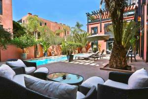 a patio with lounge chairs and a swimming pool at Somptueux Riad dans Resort 5 étoiles in Marrakesh