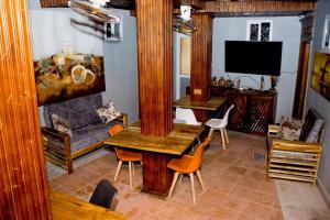 uma sala de estar com um sofá, uma mesa e cadeiras em Swahili Homes- Ada Estate em Dar es Salaam