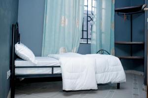 sypialnia z łóżkiem z białą pościelą i oknem w obiekcie Swahili Homes- Ada Estate w mieście Dar es Salaam
