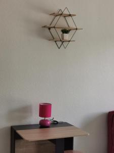 un tavolo con una lampada rosa sopra di le cosy du beau lieu immozen 46 a Beaulieu-sur-Dordogne