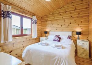 um quarto com uma cama num chalé de madeira em Trewythen Lodges em Caersws
