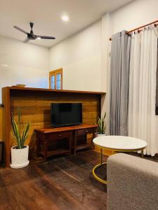 uma sala de estar com uma televisão de ecrã plano e uma mesa em Roya Khmer House em Siem Reap