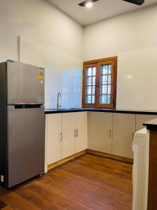 an empty kitchen with a stainless steel refrigerator at Roya Khmer House in Siem Reap