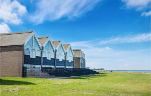 a building on a grass field next to the ocean at Nice Home In Assens With Kitchen in Assens