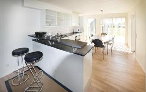 a kitchen with black counter stools and a dining room at Nice Home In Assens With Kitchen in Assens