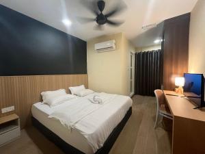 Un dormitorio con una cama con ventilador de techo. en Halo Hotel, en Semporna