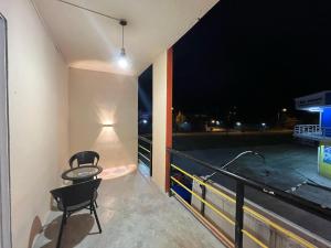 una mesa y 2 sillas en un balcón por la noche en Halo Hotel, en Semporna