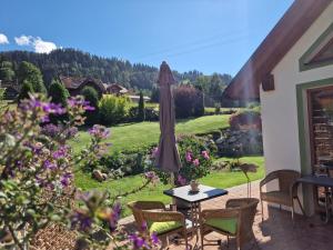 un patio con mesa y sombrilla en Appartement BERGTRÄUME en Haus im Ennstal