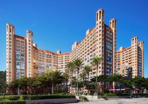 a large building with palm trees in front of it at Beach Resort Green Bay in Wanli