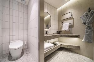 a bathroom with a toilet and a sink and a mirror at Take Hotel Seoul Gwangmyeong in Gwangmyeong