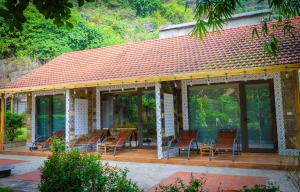 - un bâtiment avec des chaises, une table et des fenêtres dans l'établissement Green Mountain Homestay, à Ninh Binh