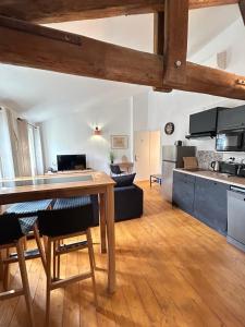 een keuken en woonkamer met een tafel in een kamer bij Chez Sam et L'As du Forum, Centre ville in Arles