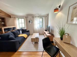 een woonkamer met een blauwe bank en een tafel bij Chez Sam et L'As du Forum, Centre ville in Arles